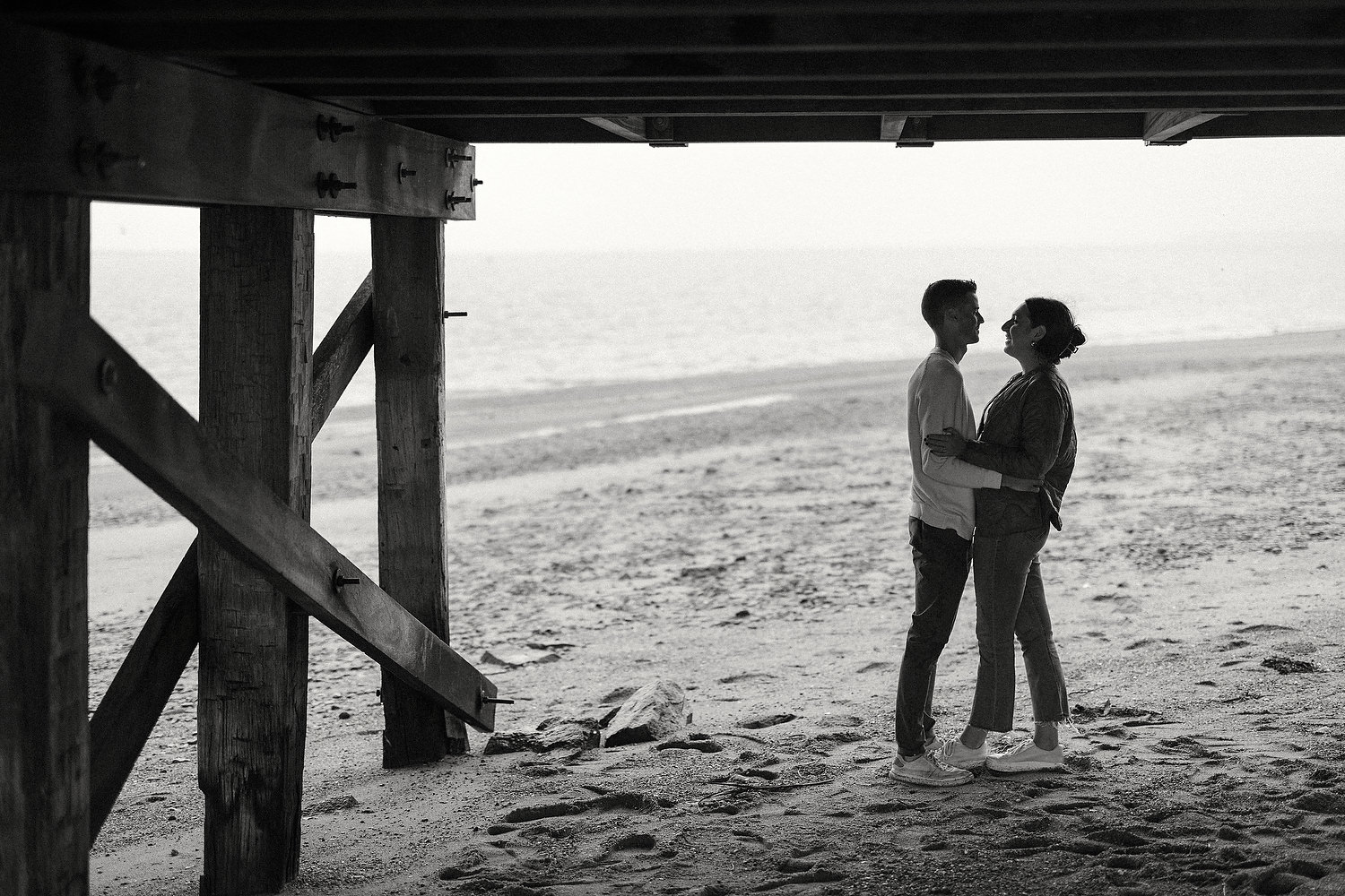 Film photograph of engagement ring glinting on sand at Duxbury Beach