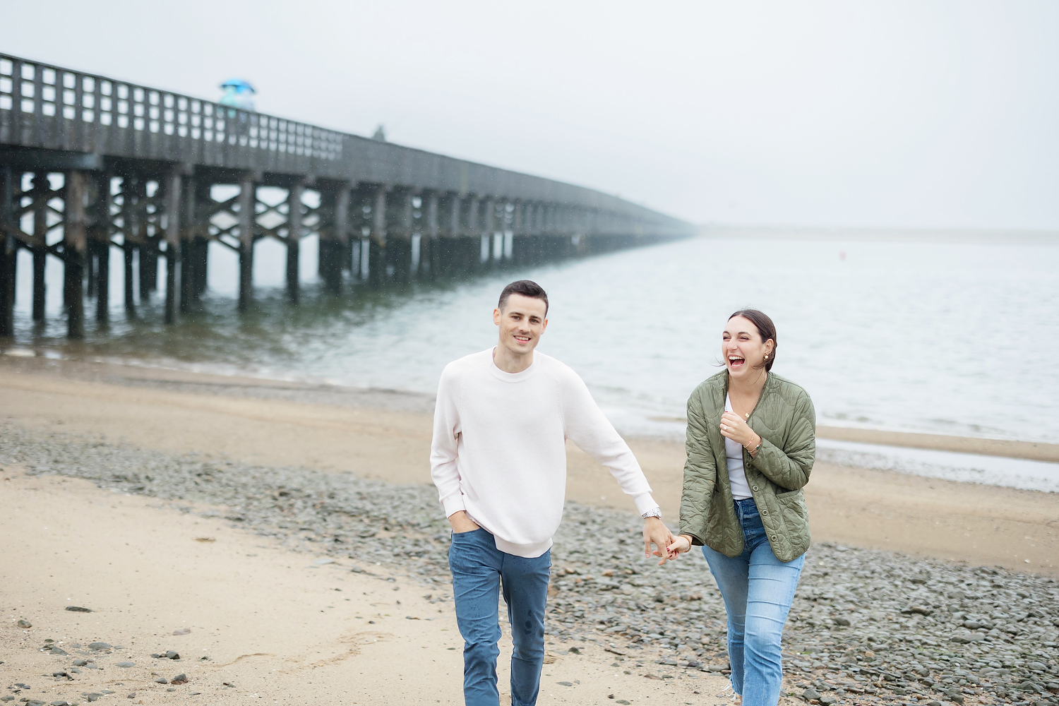 Wide shot of Duxbury Beach shoreline framing the engagement moment