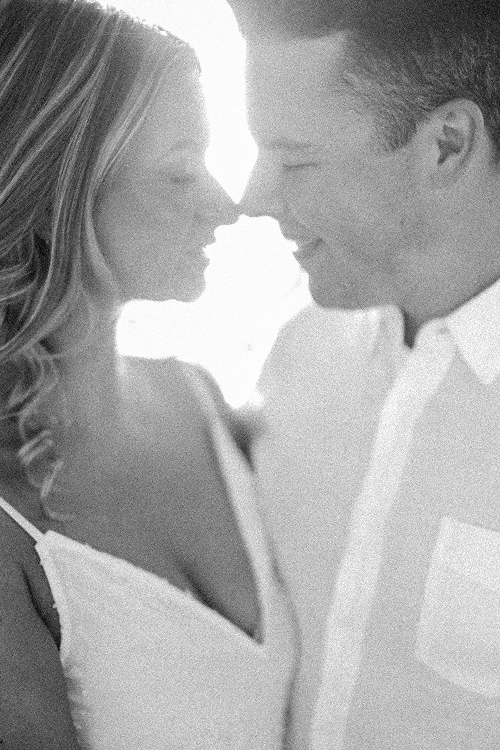 Film photo of couple laughing as waves recede in Dennis, Cape Cod