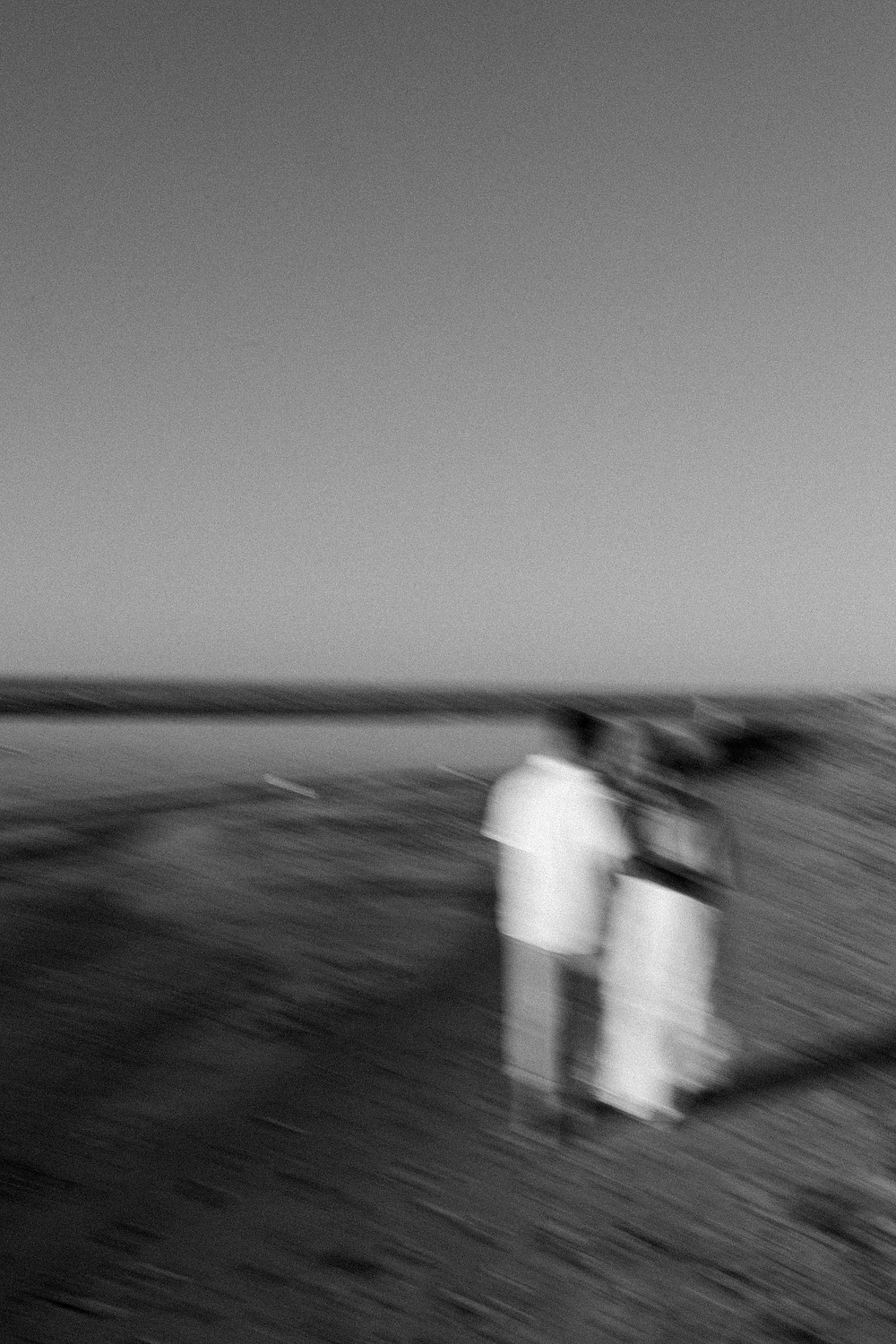 Close-up of hands and engagement ring with golden reflections on wet sand