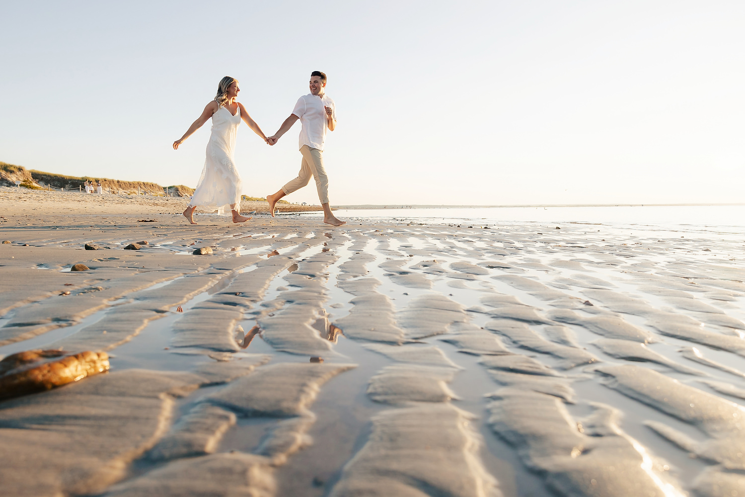 Romantic film photo of couple surrounded by tidal reflections at dusk