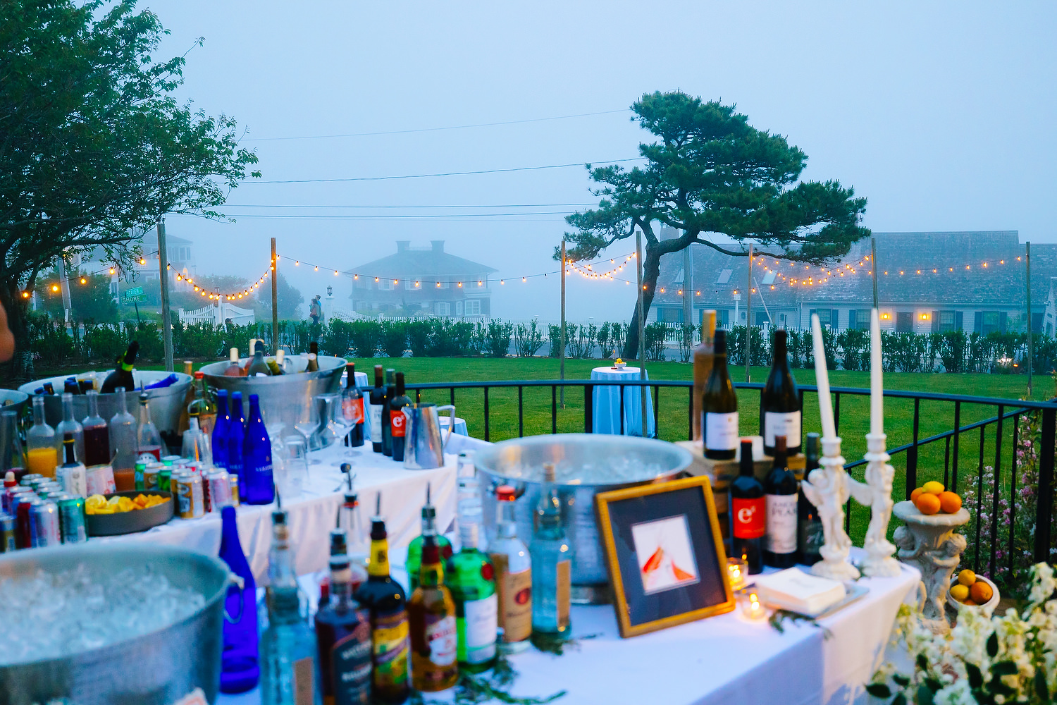 Guests mingling under lantern light during Cape Cod welcome event