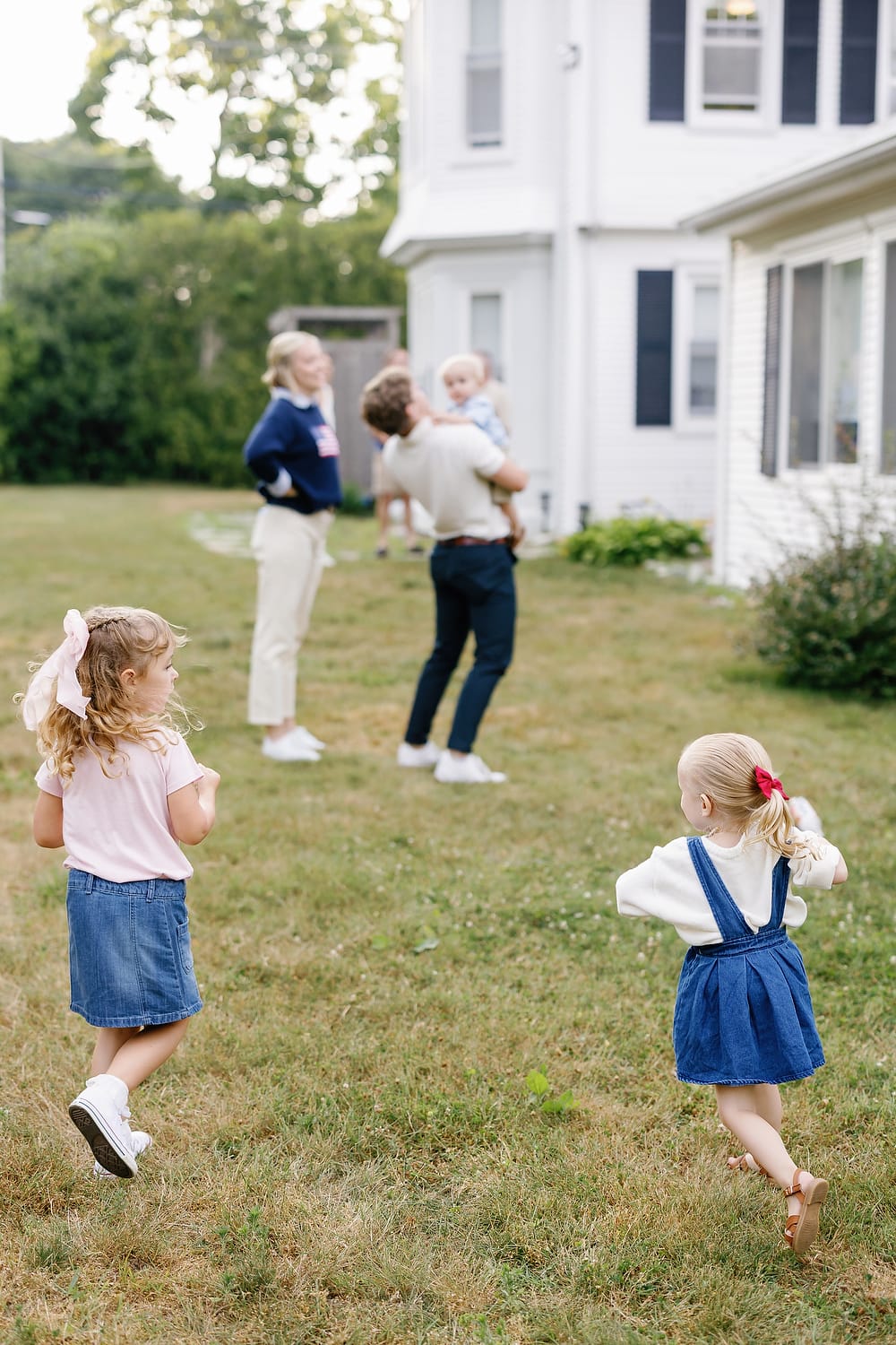 Kids running across the lawn with Cape Cod marshland behind them